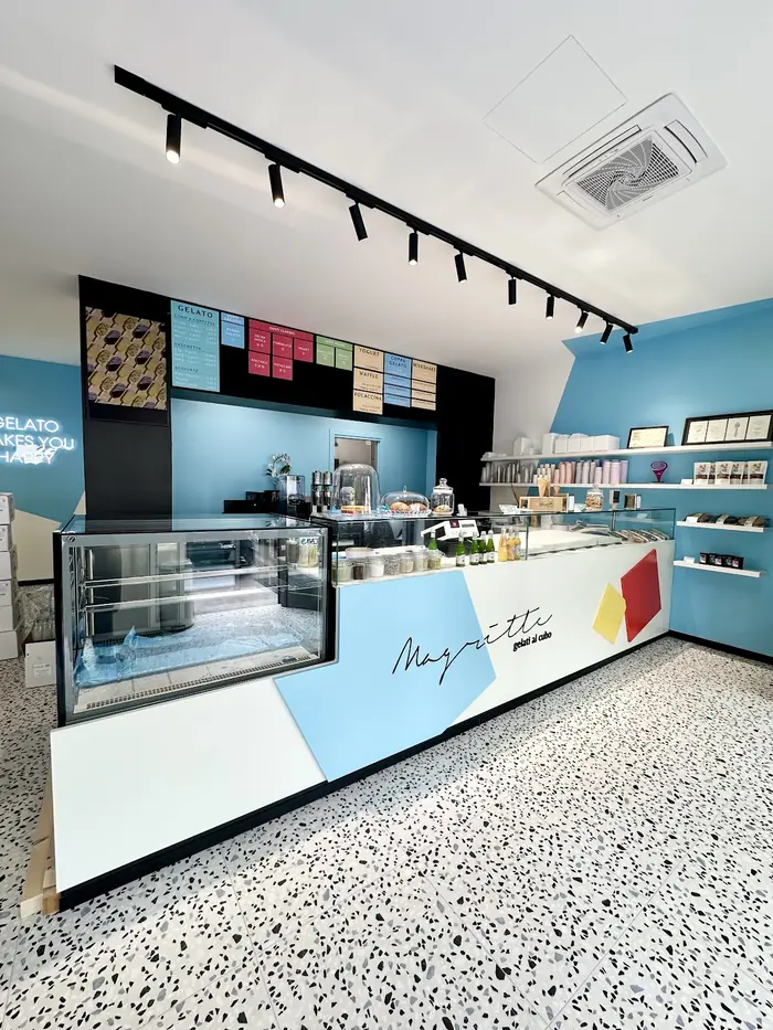 Il negozio di Piacenza: banco del gelato, pavimento alla veneziana e scaffali con praline