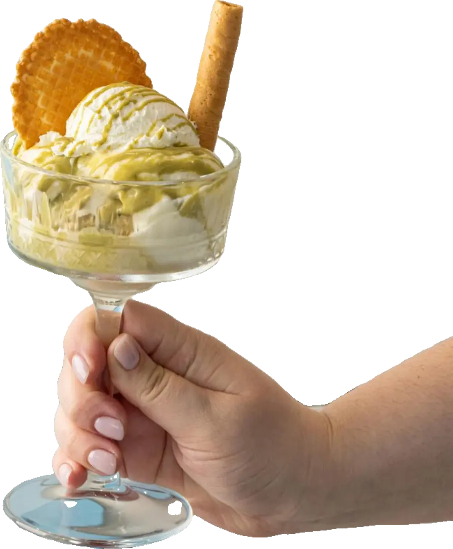 Una mano tiene una coppa di vetro con gelato, cialda e cannolo croccante