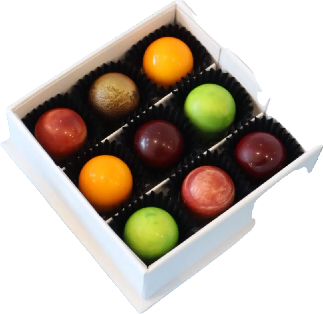 Scatola bianca aperta con nove praline colorate